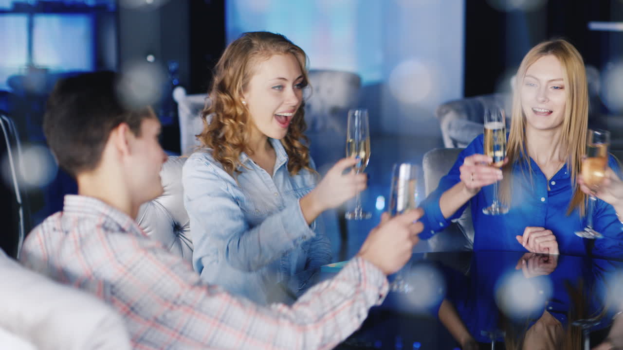 한 무리의 젊은이들이 클럽 2의 테이블에서 즐거운 시간을 보냅니다.