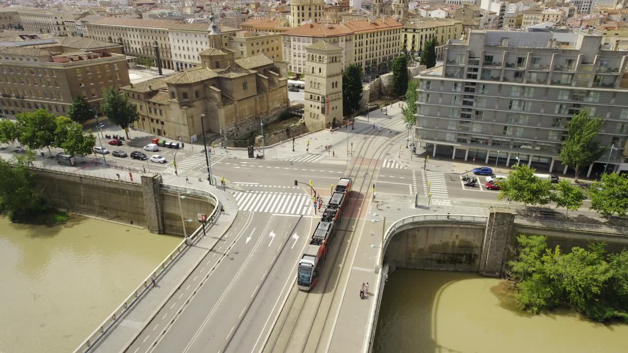 Aerial view of Zaragoza, Spain, featuring the Basilica of Our Lady of the Pillar, Ebro River, and a tram crossing a bridge