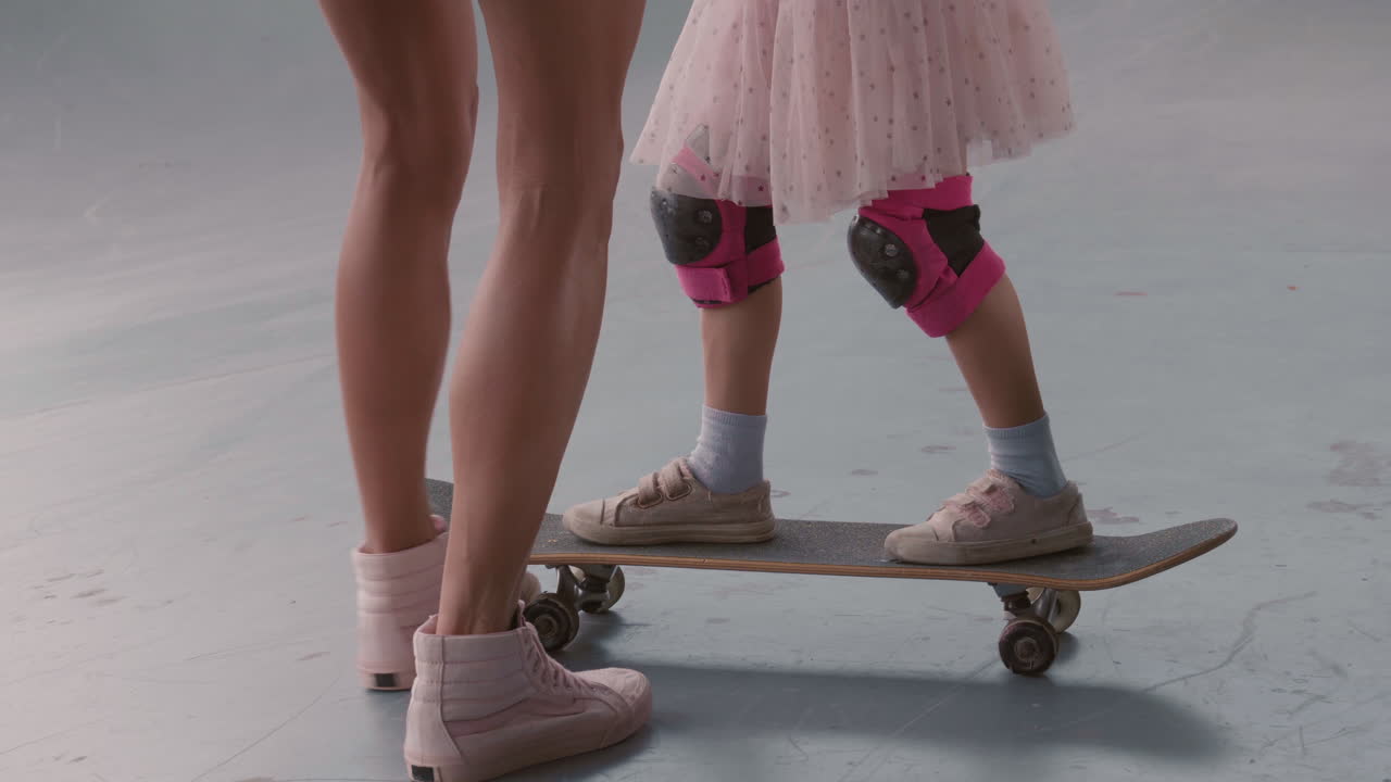 mujer irreconocible enseñando a su hija a patinar