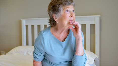 senior woman sitting on bed in bedroom 4k