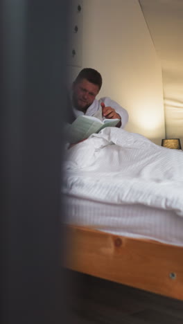 Lovers enjoy book in bed at glamping. Young people read novel resting in cozy bedroom at night. Comfortable retreat for tourists seeking relaxation