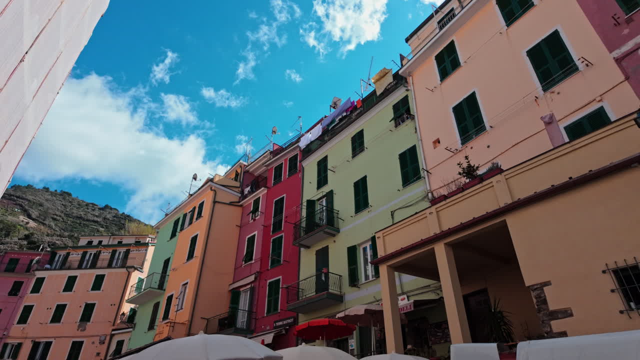Colorful buildings of Manarola under a bright blue sky, reflecting coastal charm