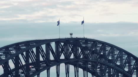 national flags of australia sway in wind on top of famous harbour bridge in sydney