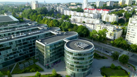 aerial rise over pomeranian science and technology park gdynia - at sunset on a summer day with apartment district on background