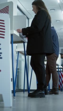 vote here sign on the floor. diverse american citizens vote in booths in polling station office. national elections day in the united states. political races of us presidential candidates. civic duty.