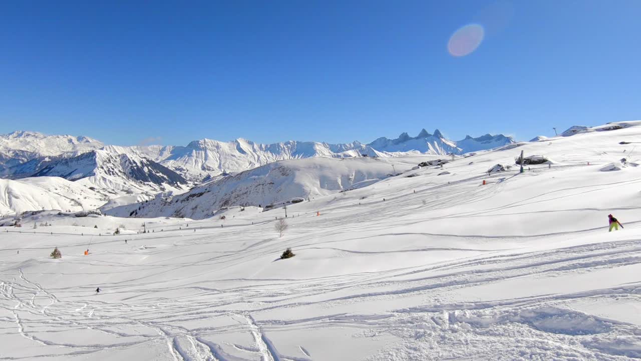 tiro de dron de esquiadores esquiando sobre una ladera de montaña nevada, fuera de pista