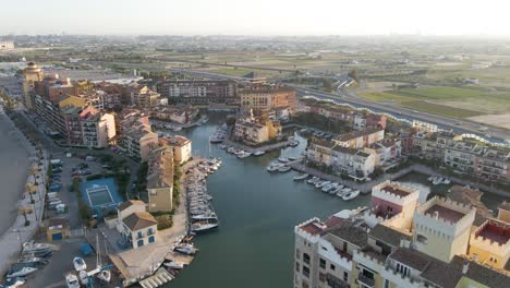 aerial high angle overview of port saplaya marina at sunrise with boats docked along the calm harbor