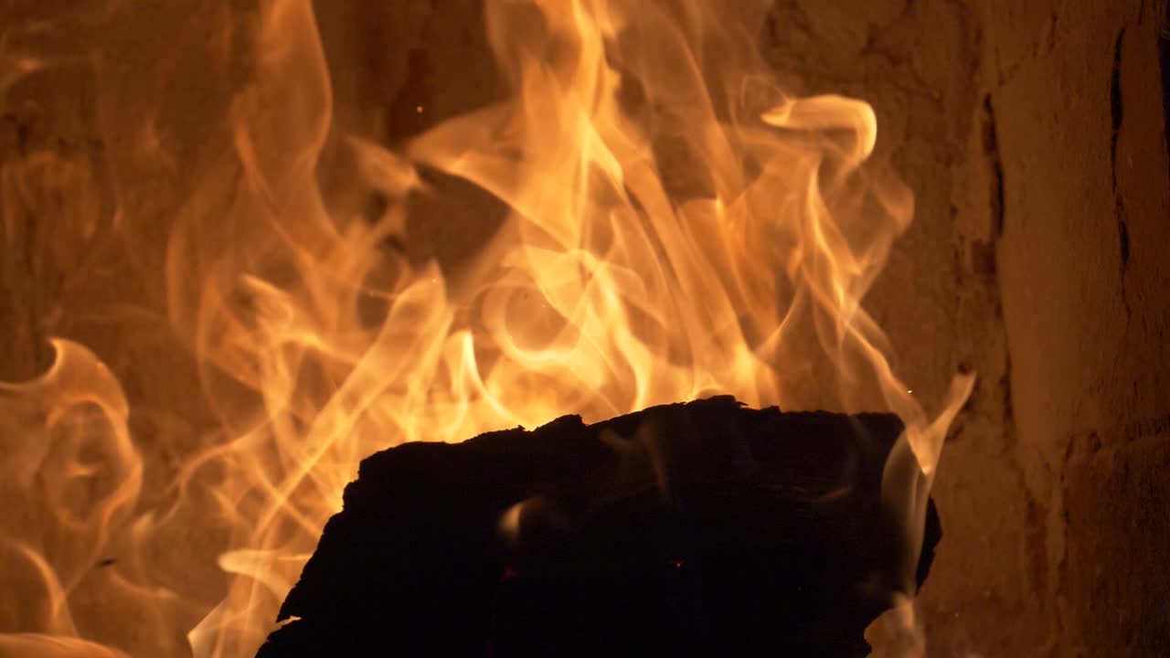 Leña ardiendo en una estufa de azulejos a 180 fps en cámara lenta - movimiento de inclinación hacia arriba
