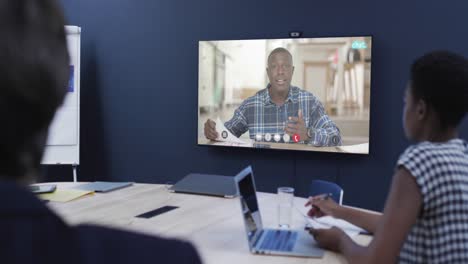 Diverse-business-people-on-video-call-with-african-american-male-colleague-on-screen