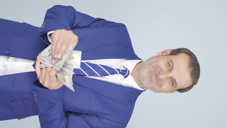 video vertical de un hombre de negocios contando dinero mirando a la cámara.
