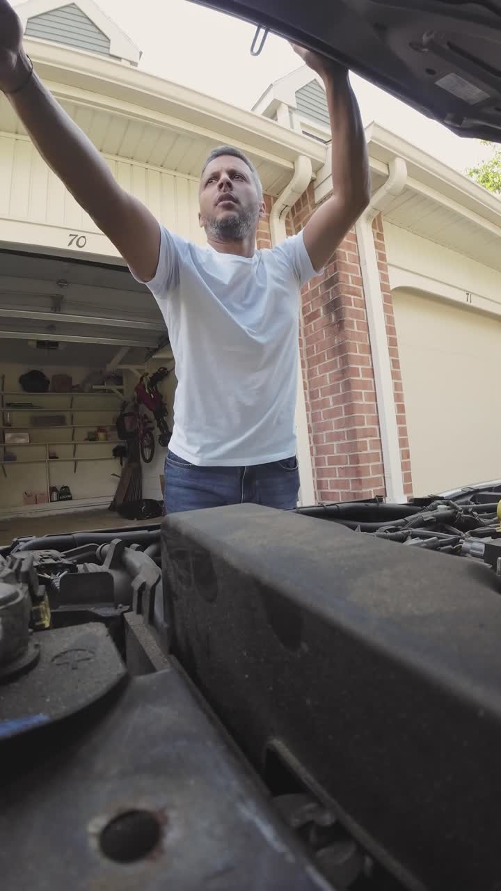 Man Checks Car Engine Oil Level with Dipstick