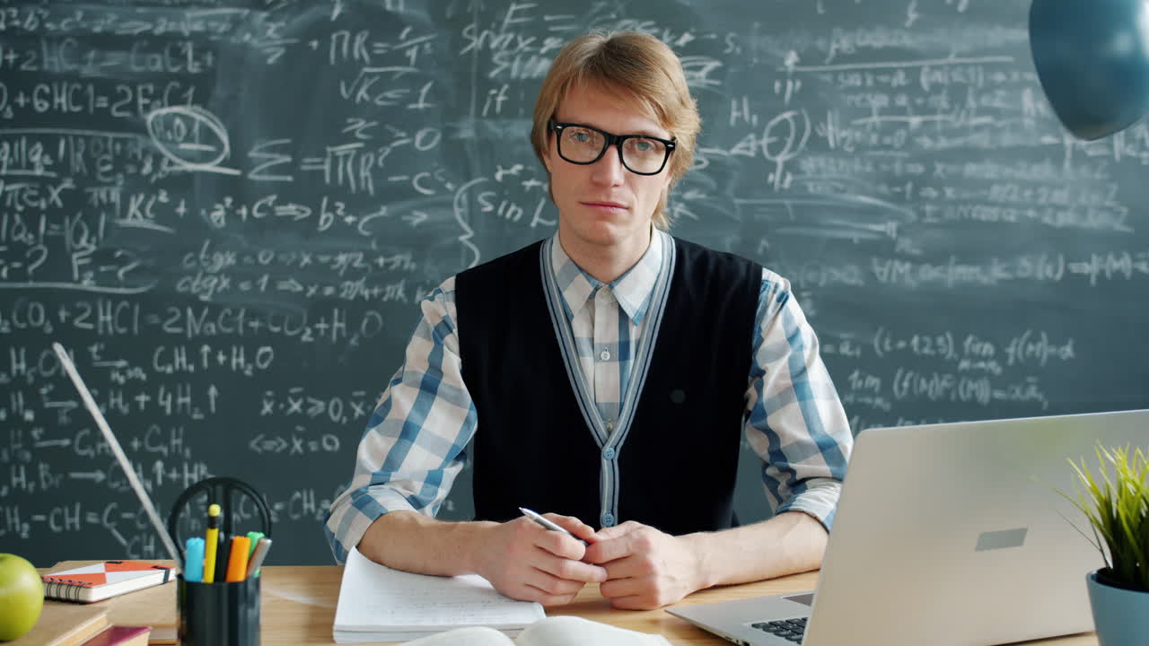 Lehrer arbeitet an einem Schreibtisch im Klassenzimmer