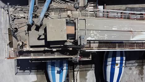 wide overhead aerial view of a concrete mixing plant as the concrete is moved to the mixer