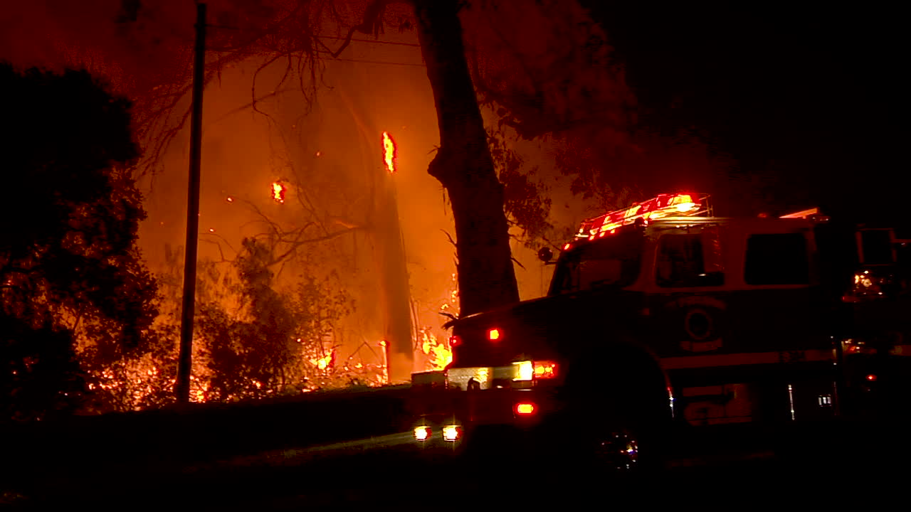 전경에 소방차가 있는 골레타 캘리포니아의 휴일 화재 동안 밤에 숲이 불타고 있습니다.