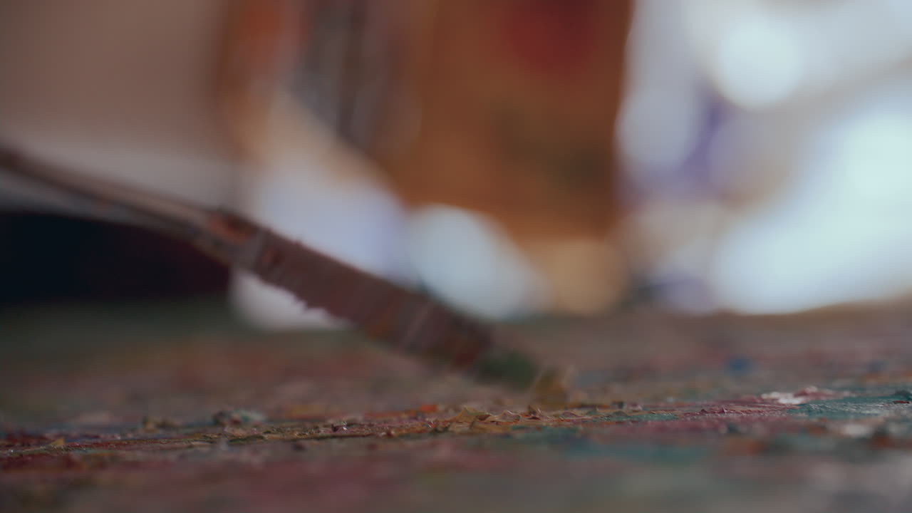 Macro di pittore che usa una spatola per stratificare pittura a olio su tela