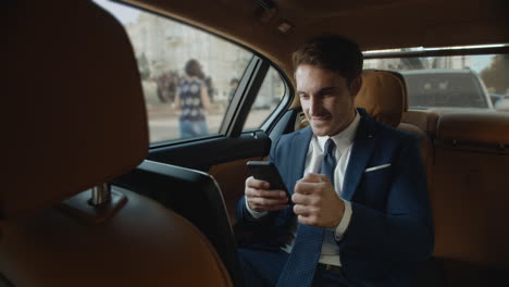 Überraschter-Geschäftsmann,-Der-Im-Innenraum-Eines-Modernen-Autos-Gute-Nachrichten-Auf-Dem-Smartphone-Erhält.