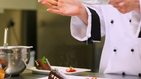 chef sieving icing sugar over a dessert