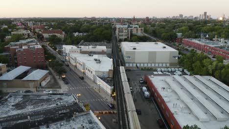 Die-Drohne-Schwenkt-Nach-Oben,-Während-Der-CTA-U-Bahn-EL-Zug-Durch-Das-Viertel-Von-Chicago-Fährt