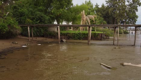 lateral view of impact of global warming on dried parana river with wooden dock over, argentina