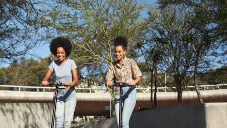 Two-mixed-race-women-riding-electric-scooter