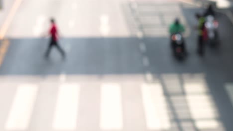 people and motorcycles navigate a crosswalk