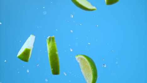 Bunch-of-lime-slices-flying-in-air-with-water,-launched