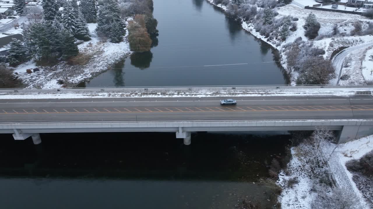 눈이 땅을 덮고 있는 다리를 가로질러 운전하는 자동차의 조감도