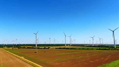 wind turbines produce clean energy. wind turbines spin in a vast field under a clear blue sky, contributing to renewable energy production