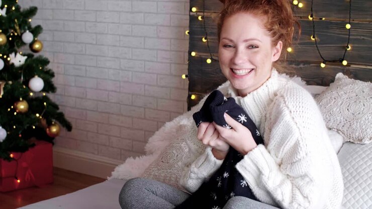 Ritratto di ragazza felice che apre i regali di Natale