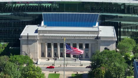 american flag waving in front of indianapolis public library