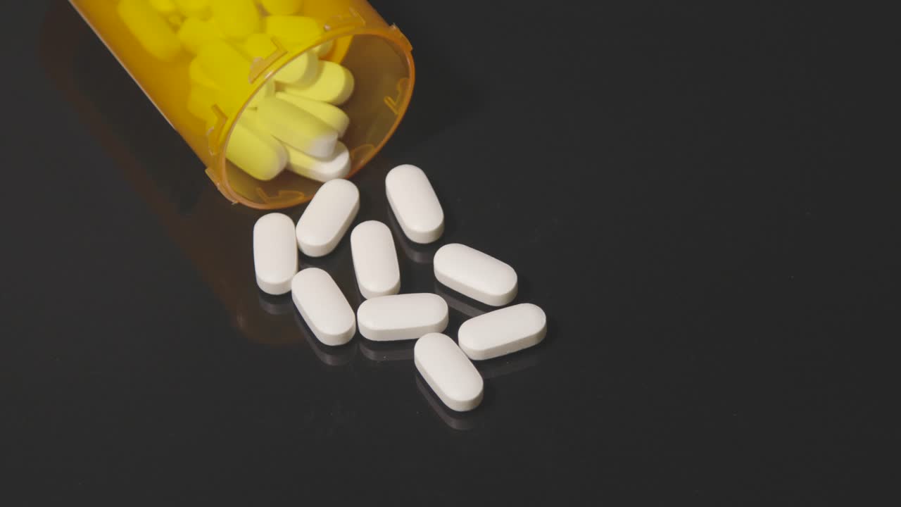 opioid white pills on table for health addiction pain medicine black table