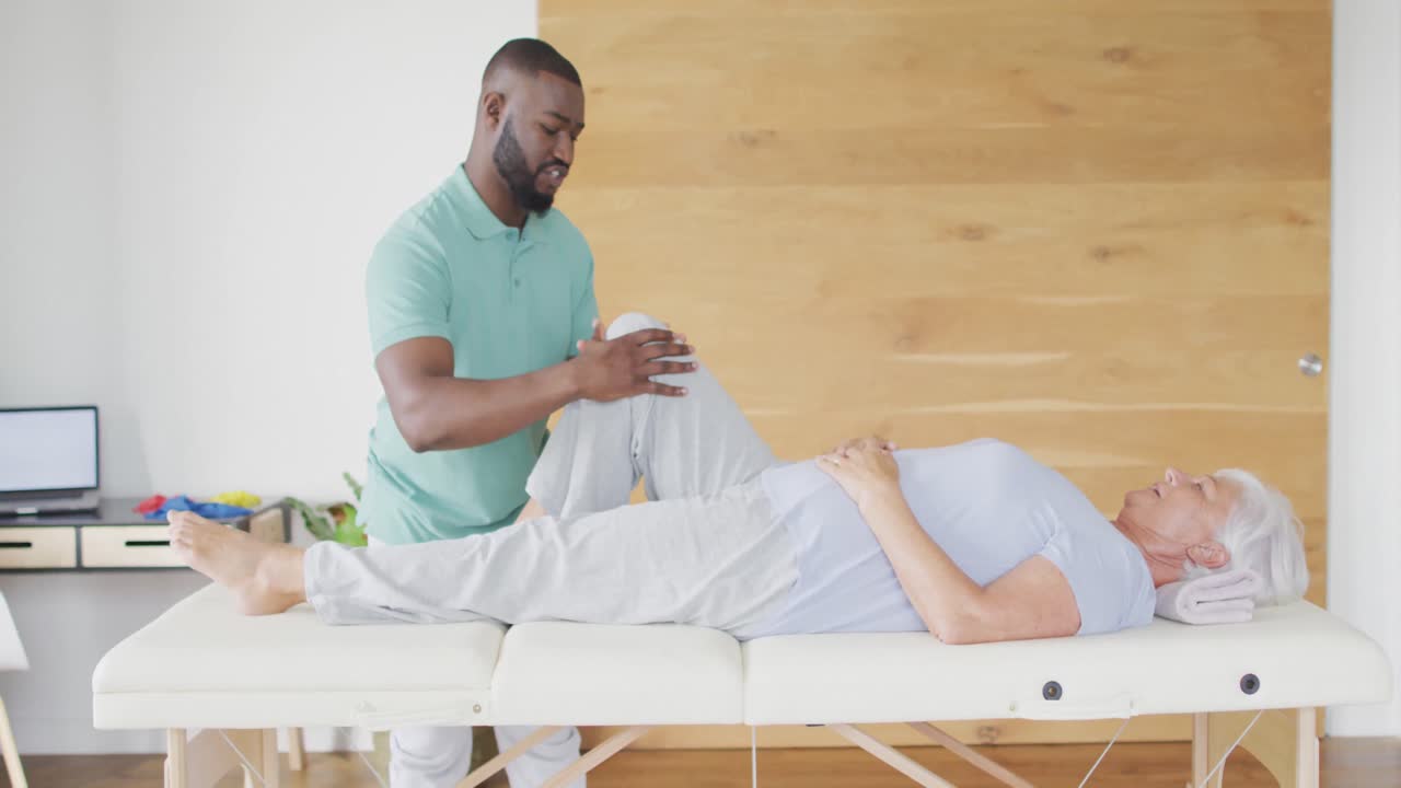 video de un fisioterapeuta afroamericano haciendo ejercicio con una mujer caucásica mayor