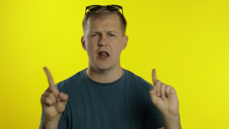 portrait of young caucasian man posing in green t-shirt. happy handsome guy celebrates and dances