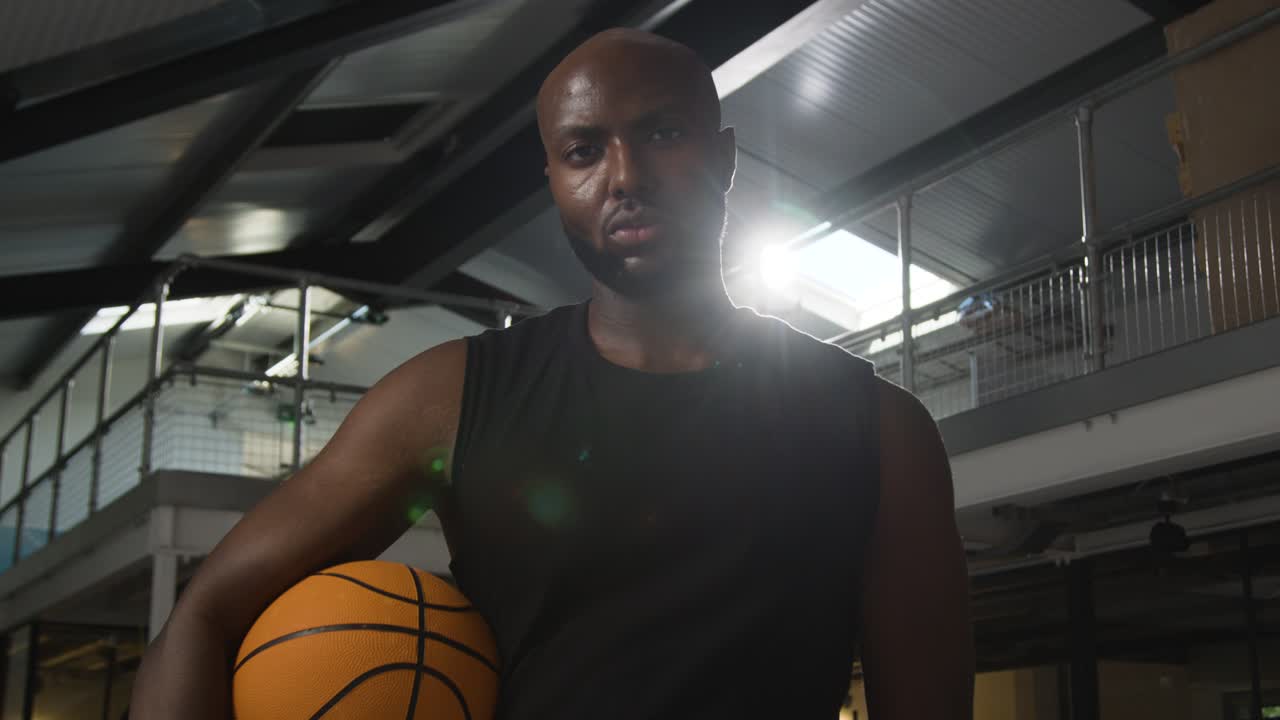 retrato de un jugador de baloncesto masculino en la cancha sosteniendo la pelota bajo el brazo 3