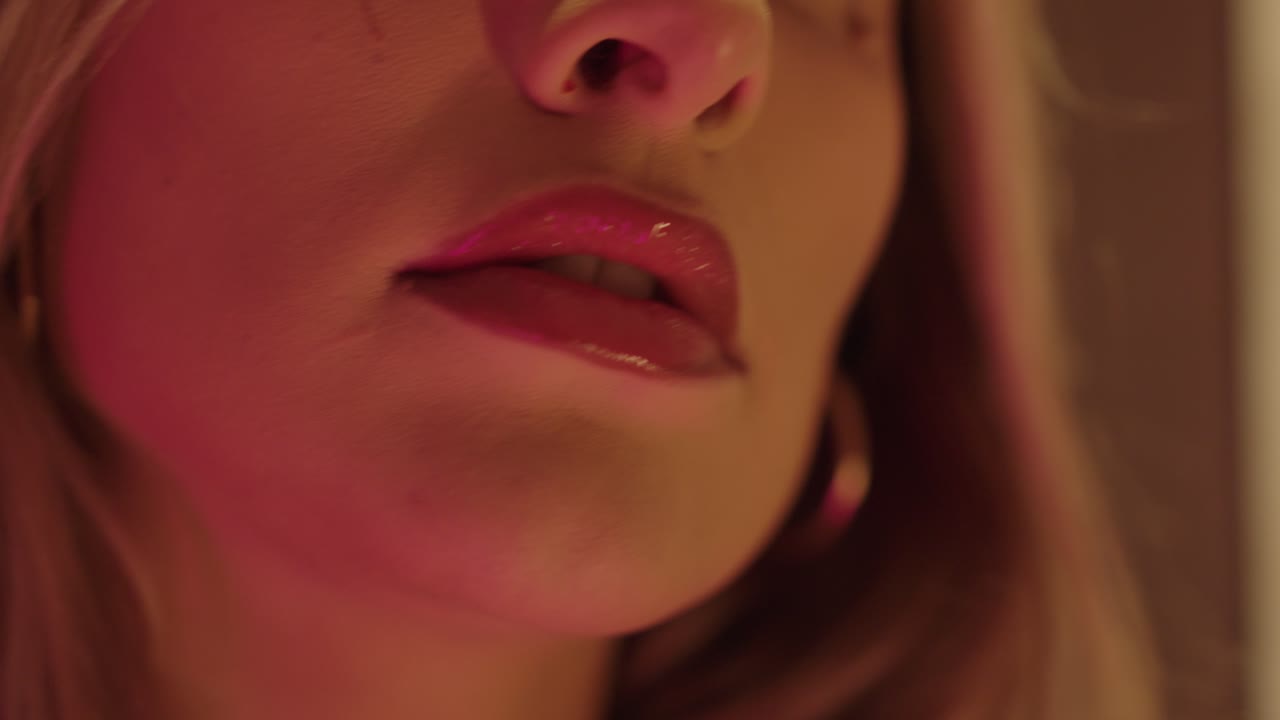 beautiful blonde woman, with beautiful lipgloss and french nails, touches itself on the neck and face close up