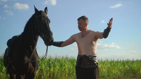 a man stands near a horse in a field 02