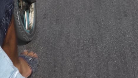 Close-up-view-from-the-backseat-of-a-traditional-Cuban-Cicle-Taxi-of-the-male-driver's-foot-pedaling-and-the-wheel