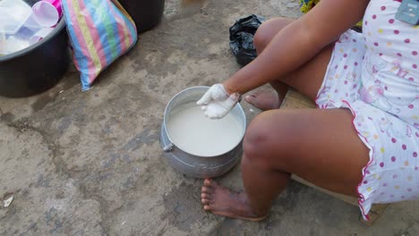 pouring yeast and water to make the mixture for banku, the national dish of ghana