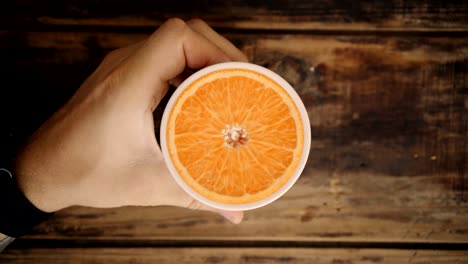 top view loop of hand holding cup with orange inside