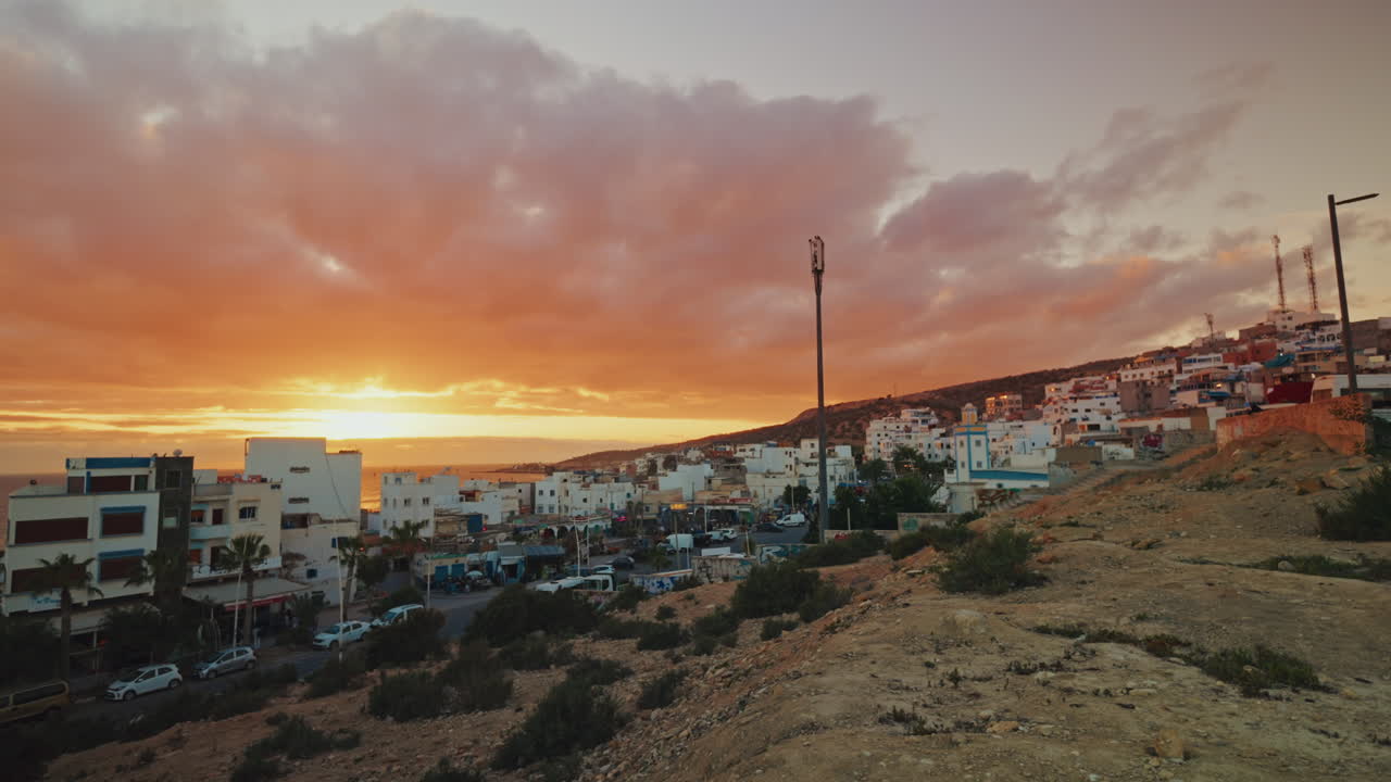 Panoramic view of the local town of Taghazout in Morocco at sunset. Warm dramatic sky, sunlight coming through the clouds.