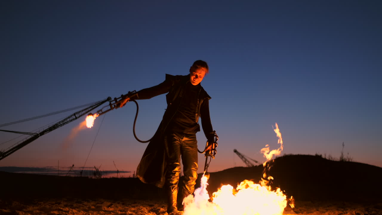 A man with a flamethrower at sunset in slow motion. Costume for zombie Apocalypse and Halloween