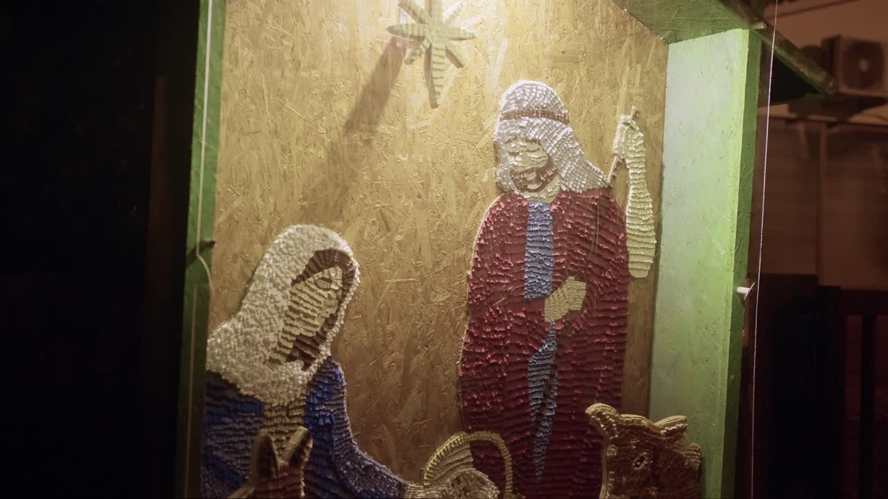 handcrafted nativity scene featuring Mary, Joseph, and a manger, illuminated at night