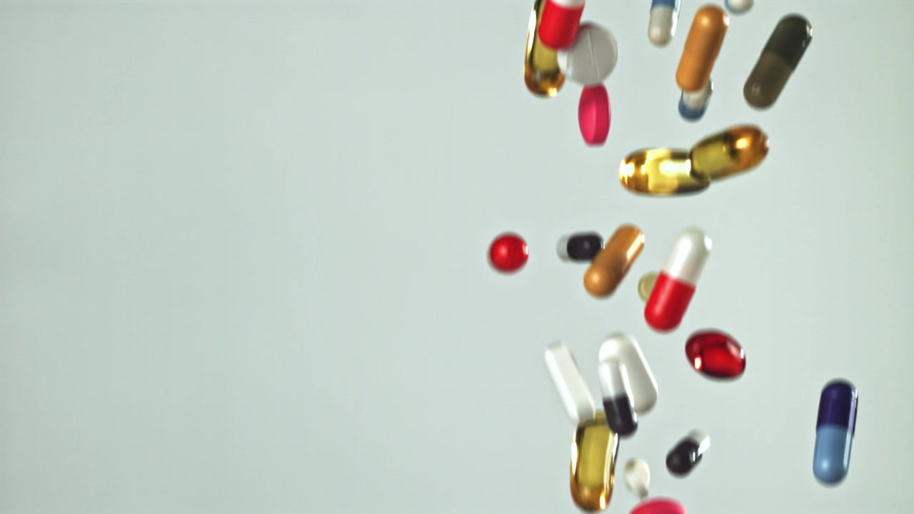 Colorful Pills and Capsules Falling in Slow Motion