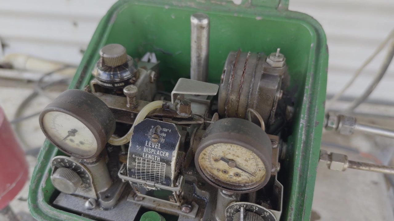 Close-up view of an analog level controller using pressure gauges, pneumatic relays, and a nozzle-flapper mechanism for industrial process measurement and control.