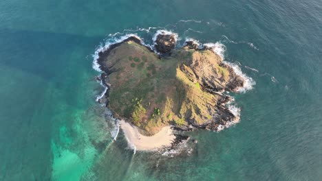 aerial drone footage of mokulua island birds eye view with clear reef and ocean at sunrise