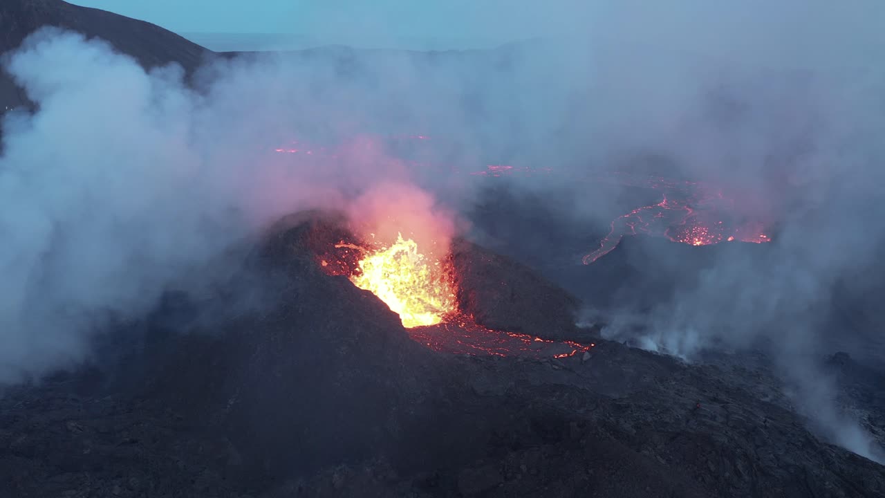 Lava gets ejected from spatter cone with clouds of toxic smoke in Iceland