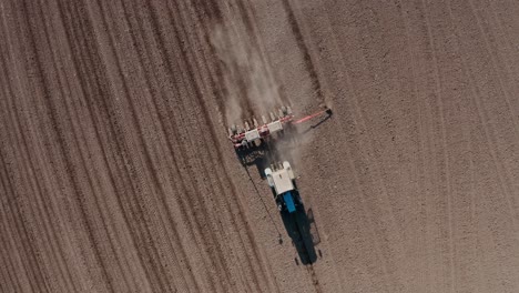 aerial view of a tractor plowing dry agricultural field, preparing land for sowing, drone video. agricultural industry. processing the field in the farm.