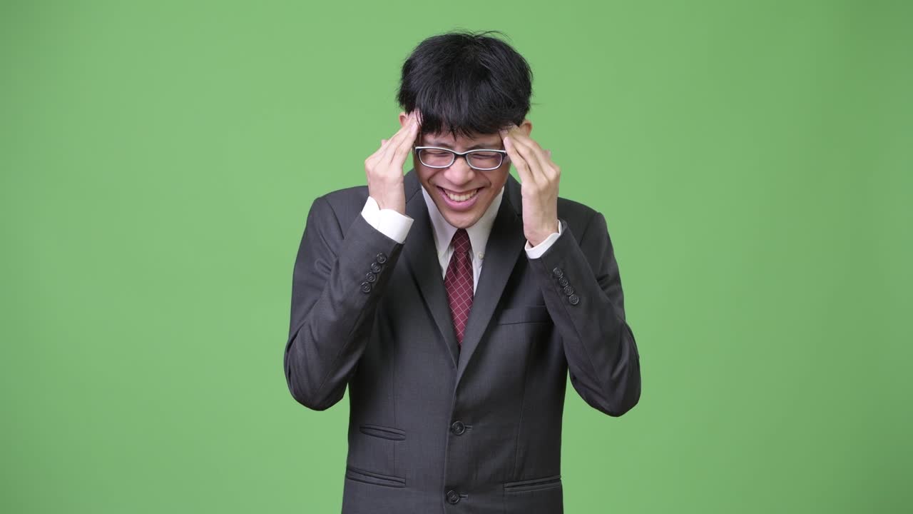 머리가 아프고 있는 젊은 스트레스를 받은 아시아 사업가