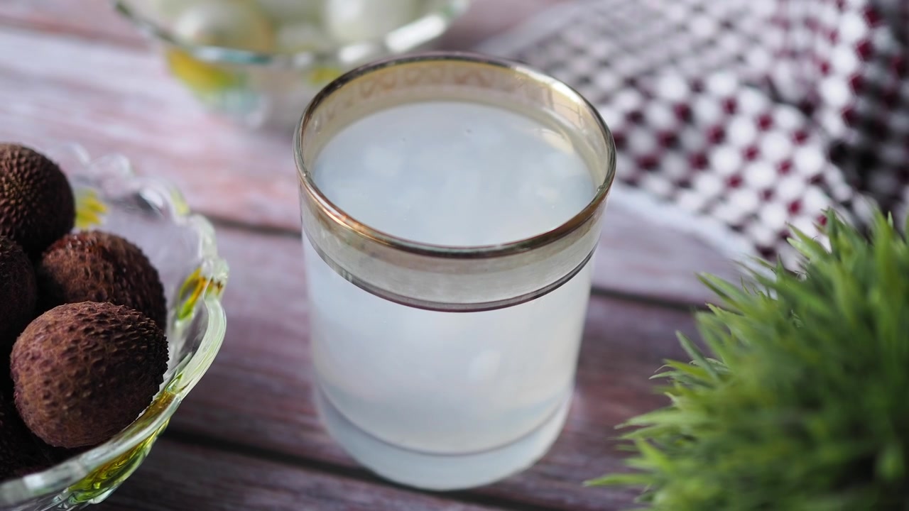 Bicchiere di succo di litchi rinfrescante su un tavolo di legno