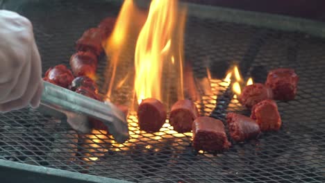 chorizo and sausages being cooked on a grill